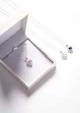 Collar de plata 925 con dije en forma de corazón con una zirconia azul central rodeada de pequeñas zirconias blancas.