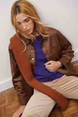 Chaqueta color camel de cuero sintético con cuello camisero, cierre frontal de botones a presión y dos bolsillos de parche en el pecho.