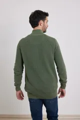 Cardigan azul de tejido de punto con cierre frontal y cuello alto.