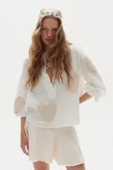 Minifalda blanca de denim con diseño evasé, godets que aportan movimiento y ruedo desflecado.