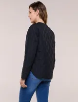 Campera matelaseada color verde militar con diseño capitoneado de rombos, escote redondo sin cuello y cierre frontal con broches a presión. Cuenta con bolsillos frontales oblicuos y ruedo curvo con aberturas laterales.