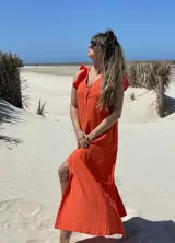 Vestido largo fucsia de lino, con corte recto, breteles anchos con volados y botones frontales. Presenta un tajo lateral.