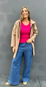Sweater de punto acanalado color fucsia, con escote en V y mangas largas con puños lisos. Diseño entallado y tejido suave.