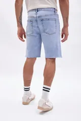 Bermuda de jean azul claro con diseño clásico, tiro medio y dobladillo deshilachado con roturas sutiles.