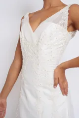 Vestido de novia blanco de seda y organza con apliques de cruni, bordados en perlas y canutillos. Sin mangas, con breteles transparentes y espalda terminada en V con cinta para cerrar tipo corset.