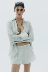 Short de algodón con estampado de rayas verticales finas en tonos verde menta y blanco. Presenta cintura elástica y corte holgado.