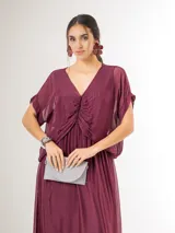 Vestido midi de seda italiana color bordó, con escote en V, sobrecapa fruncida y diseño fluido. Cuenta con mangas cortas amplias y elástico en la cintura.