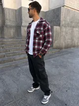 Chaqueta de paño a cuadros con diseño de estampado en tonos rojo, negro y blanco, bolsillos frontales con solapa y botones.