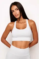 Top deportivo de alto rendimiento con diseño de espalda nadador, confeccionado en tejido técnico con protección UV50+. Cuenta con bolsillo trasero y bolsillo interno en el forro frontal, además de detalles reflectivos para mayor visibilidad.