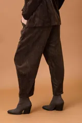 Pantalón baggy de corte holgado y silueta amplia, confeccionado en tela con textura aterciopelada. Presenta cintura elástica y bolsillos laterales.