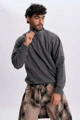 Buzo deportivo gris con cuello alto y cierre frontal parcial, de manga larga y diseño holgado.