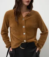 Cardigan de tricot con textura efecto peluche, color negro, de calce regular, escote redondeado y cierre frontal con botones.