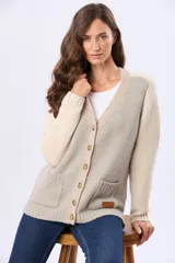 Saco tipo cardigan de tejido grueso con diseño de bloques de color en beige, rosado y blanco. Cuenta con botones frontales y dos bolsillos delanteros.