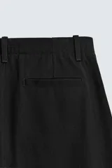 Pantalón de corte balloon fit confeccionado en una mezcla de lyocell y algodón. Presenta cierre frontal con cremallera y botón, bolsillos laterales y bolsillos traseros de vivo.