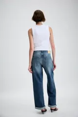 Jeans de tiro medio con diseño de cinco bolsillos, pernera holgada y bajo con vuelta. Cierre frontal con cremallera y botón.