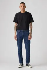 Jeans de mezclilla azul oscuro, corte skinny, con cierre de botones y tiro medio.