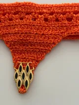Gargantilla tejida al crochet con hilo de seda viscosa color naranja, de forma triangular.