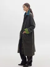 Trench oversize de lana a cuadros con cuello, puños y bolsillos de pana verde.