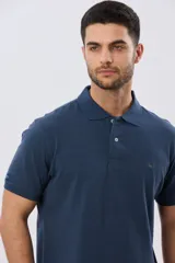 Remera polo lisa de piqué en color bordó, con cuello camisero, cierre frontal con botones y mangas cortas.