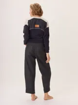 Pantalon de corte recto y tiro medio, confeccionado en tejido de lana con sutiles rayas verticales. Presenta bolsillos traseros aplicados, costuras reforzadas en las rodillas y ruedo con dobladillo.