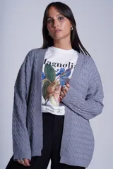 Cárdigan negro de tejido de punto trenzado, sin botones y corte holgado.