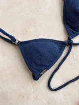 Top de bikini verde militar brillante, estilo triángulo, con argollas decorativas, bretel decorativo removible, forro y relleno removible. Los breteles son regulables y se ata en la espalda.