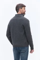 Buzo de tejido de punto color gris, con cuello alto y cierre frontal parcial. Presenta un diseño de calce regular con logo bordado en el pecho.