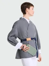 Pouch de mano color verde menta, con cierre superior y tirador con detalle de cuentas decorativas en tonos tierra y verde. Presenta el logo de la marca grabado en el frente.