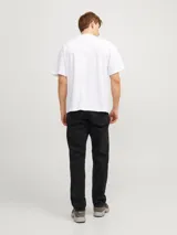 Jean negro de tiro alto, corte tapered, cinco bolsillos y cierre con botón.