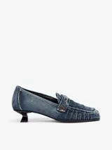 Mocasines de mujer Diesel D-Amber con taco bajo y fino, confeccionados en denim azul. Presentan puntera cuadrada, detalles fruncidos en el empeine y tira frontal con aplique metálico del logo de la marca.