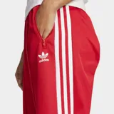 Pantalón deportivo Adidas Beckenbauer color rojo con tres tiras blancas a los costados.