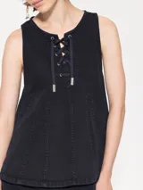 Top sin mangas color celeste claro, confeccionado en gabardina, con escote delantero ajustable mediante cordón y ojalillos. Presenta recortes triangulares que generan vuelo en la parte inferior.