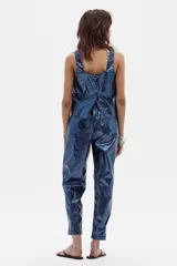 Pantalón azul brillante de corte holgado y ceñido al tobillo, confeccionado en lino. Tiene tiro medio alto y cintura elástica en la parte trasera.