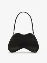 Bolso de hombro para mujer de Diesel, color negro, con forma orgánica y brillante, similar a un control de videojuegos. Posee un asa de hombro negra y un pequeño dije metálico con logo en el frente.