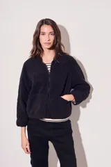 Campera negra de micropolar con cierre frontal y bolsillos laterales.