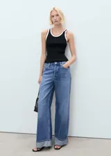 Top de punto fino sin mangas, con cuello redondo y tirantes anchos. Presenta un diseño entallado con detalles de ribetes en contraste en el cuello y las sisas.