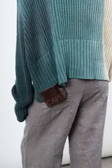 Saco de hilo con cuello alto y cierre de botones, con teñido artesanal bicolor y etiqueta de cuero grabada en la parte trasera.