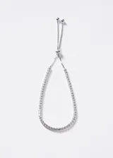 Pulsera de plata 925 con diseño tennis, decorada con una línea continua de zirconias blancas y cierre deslizante ajustable con terminales esféricas.