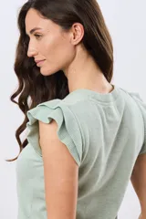 Remera tejida de algodón en color beige, de cuello redondo, sin mangas y con detalles de volados estructurados en los hombros.