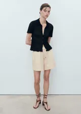 Short de corte recto confeccionado en mezcla de lino y viscosa, con cintura elástica y cordón ajustable. Cuenta con forro interior.