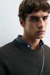 Sweater de punto en canalé color negro, de corte regular fit, cuello redondo y manga larga con terminaciones en rib.