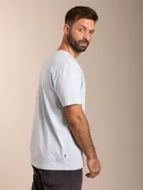 Remera de algodón color azul, de corte clásico con cuello redondo y manga corta. Presenta un pequeño bordado distintivo de un ave en el pecho.