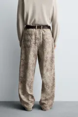 Pantalón de corte relajado confeccionado en tejido ligero de algodón con estampado abstracto de efecto lavado. Presenta cintura elástica, bolsillos frontales y bolsillos traseros de plastrón, con cierre frontal de cremallera y botón.
