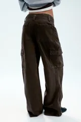 Pantalón cargo de tiro medio confeccionado en denim negro con efecto lavado. Presenta bolsillos laterales con solapa, bolsillos delanteros y traseros, corte recto y cinturón del mismo tejido incluido con hebilla metálica.