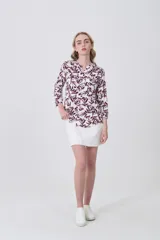 Camisa de viscosa con estampado botánico en tonos bordó sobre fondo blanco, cuello mao y cierre frontal con botones. Presenta bolsillos frontales y mangas tres cuartos.