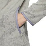 Buzo deportivo gris de tejido suave con tecnología Dri-FIT, cuello alto con media cremallera, mangas largas y bolsillo frontal.