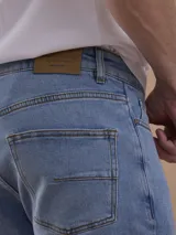 Jean azul piedra de corte recto, con diseño clásico de cinco bolsillos y cierre frontal de botón y cremallera.