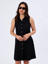 Vestido camisero corto negro, sin mangas, con cuello camisero y cierre frontal de botones.