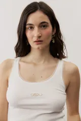 Musculosa de tejido rib color beige con detalles marrones en los bordes del cuello y sisas. Cuenta con el logotipo de la marca bordado en el pecho.