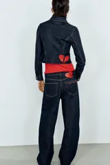 Jeans de tiro alto confeccionados en denim azul oscuro, con diseño barrel de pernera holgada que se estrecha hacia los tobillos. Cuenta con cinco bolsillos, trabillas para cinto y cierre frontal con cremallera y botón.